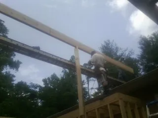 Carpenter setting a ridge beam over a new addition frame — Ice Dam Removal by Roofing Brothers in Van Hornesville
