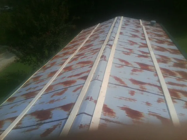 Rusted metal roof panels with new wood purlins before replacement — Storm Damage Roof Repair in Van Hornesville by Roofing Brothers
