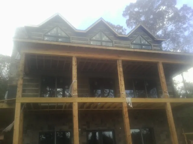 Dormers and porch framing on a large log home under construction — Roof Coating work by our crew in Van Hornesville