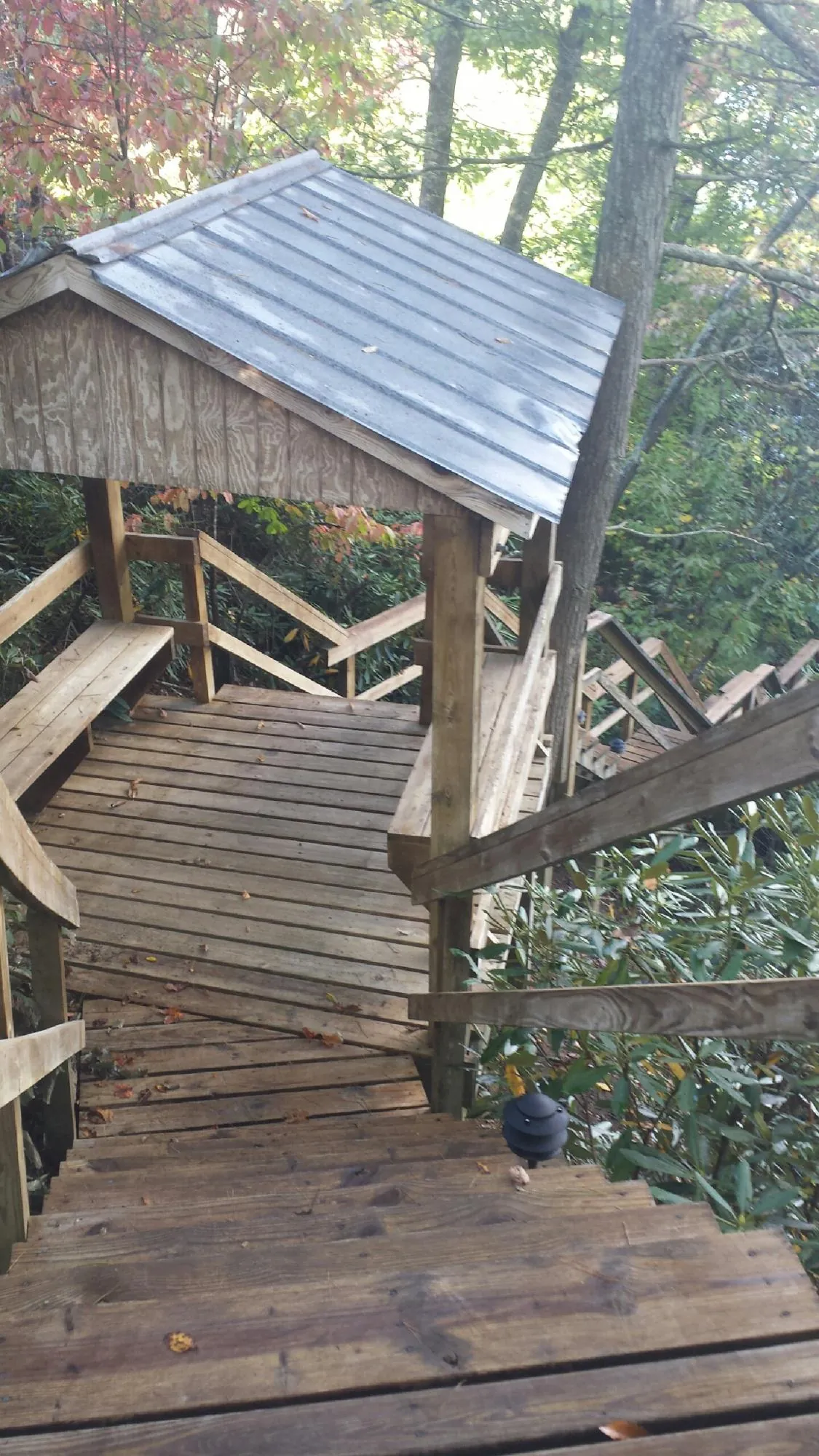 Metal roofed shelter over wooden steps on a wooded walkway — Skylight Repair & Installation work by our crew in Van Hornesville