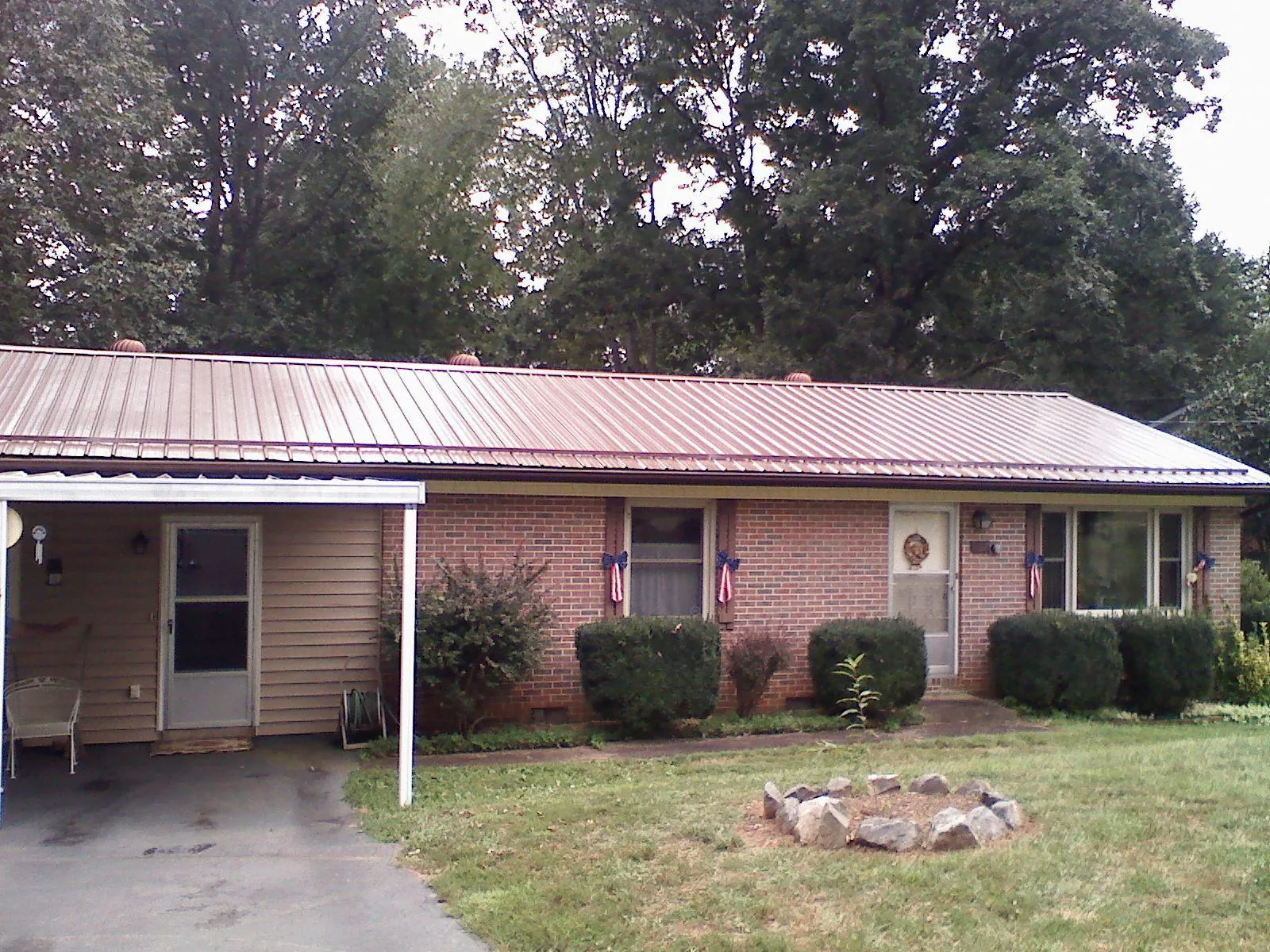 Bronze metal roof and carport on a brick ranch home — Roof Repair work by our crew in Van Hornesville